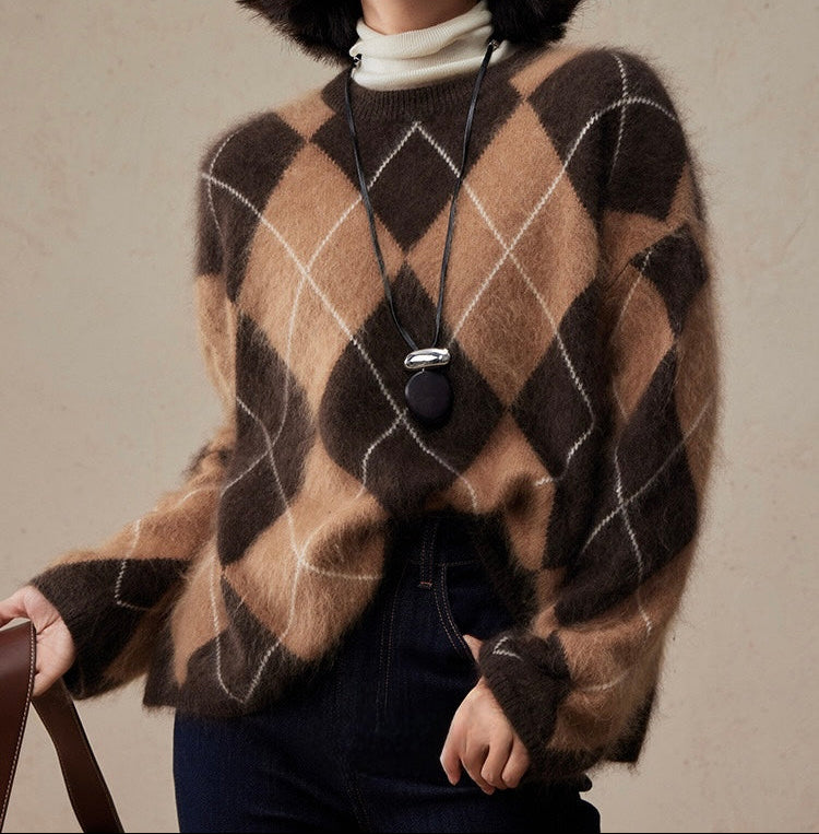 Person wearing a brown and caramel wool sweater with a necklace against a neutral background