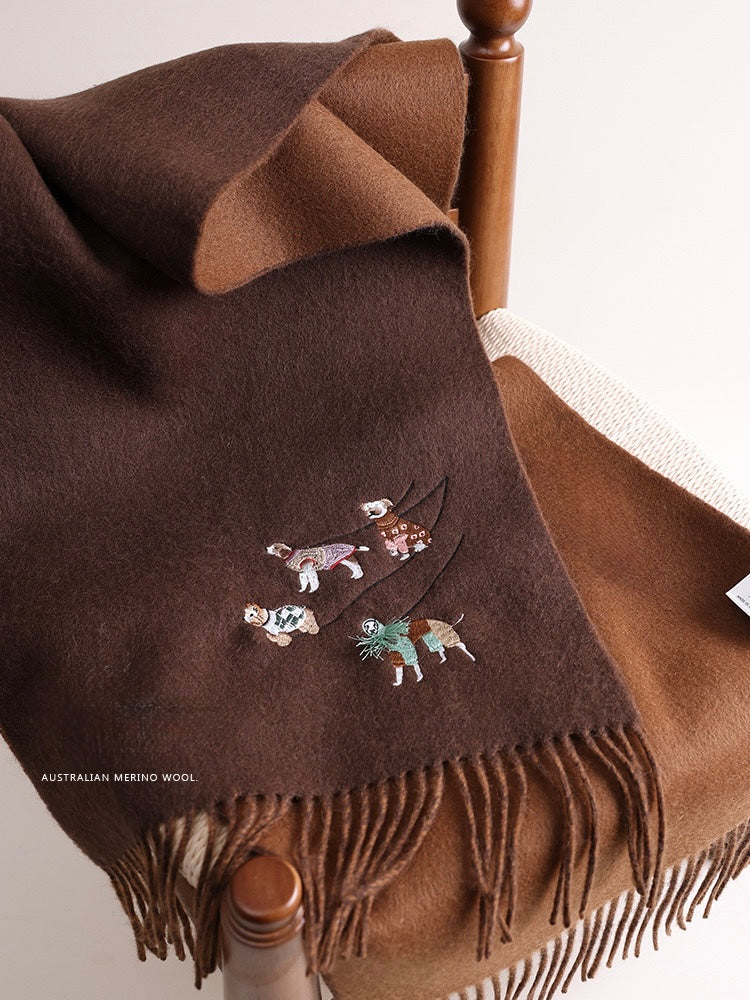 Brown wool blanket with embroidered designs draped over a wooden chair.