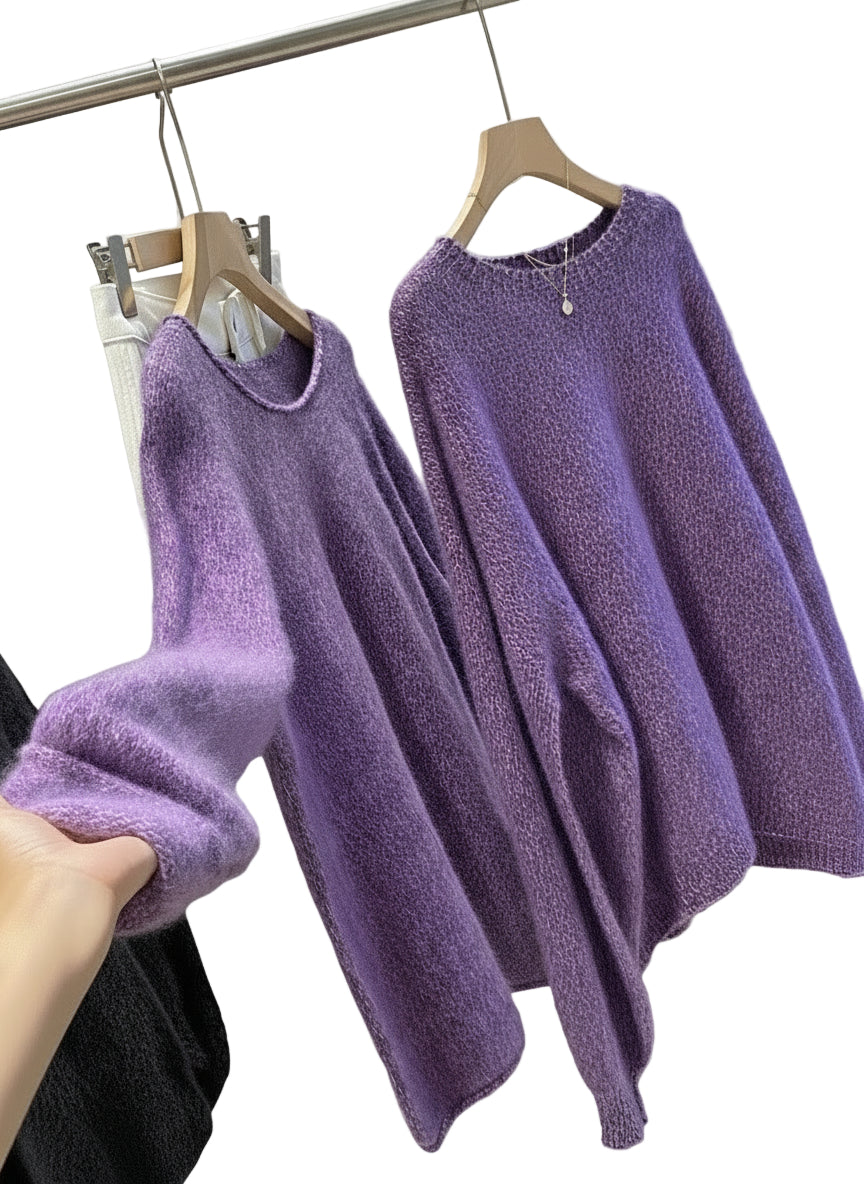 Purple fuzzy sweater on a hanger with a hand holding it, against a neutral background.