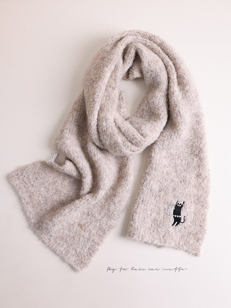 Beige scarf with a black logo on a light beige background