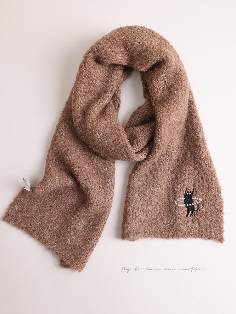 Brown scarf with a small embroidered design on a white background