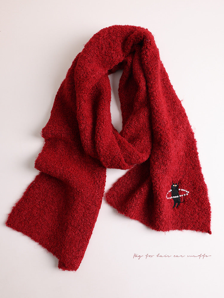 Red scarf with a small embroidered design on a light background